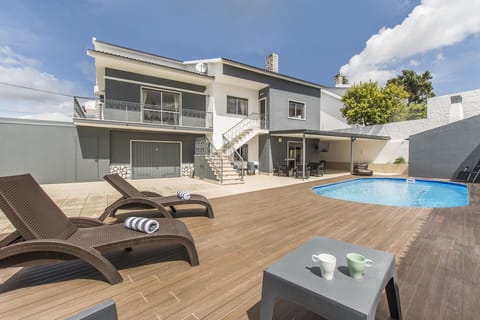 Swimming pool with sun loungers outside the house.