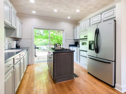 Bright and open kitchen with abundant counter space, cooking tools, dishwater and appliances.