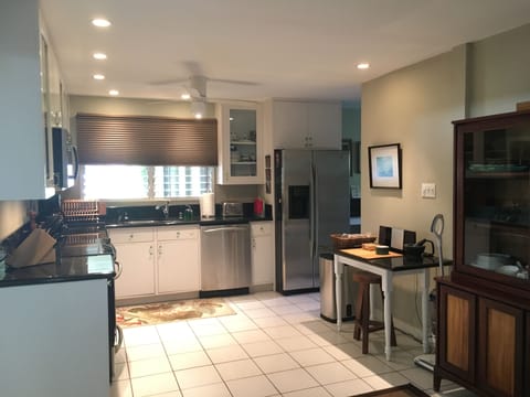 Fully stocked kitchen with stainless steel appliances and adjacent laundry room