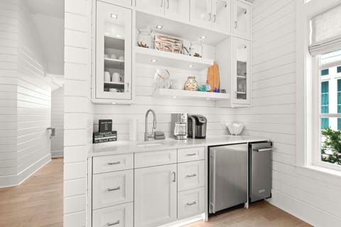 The bar includes an ice maker, mini-fridge, and coffee station