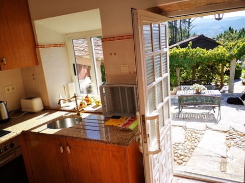 View from Kitchen two dining areas. One in the sun, and the other shaded by vine