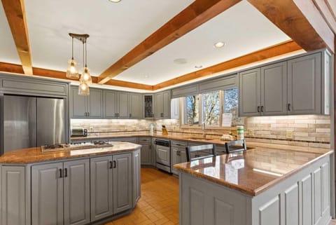 Along with Heated Brick Floors, the Kitchen Features a Gas Cooktop, Stainless Steel Appliances, and Accent Lighting