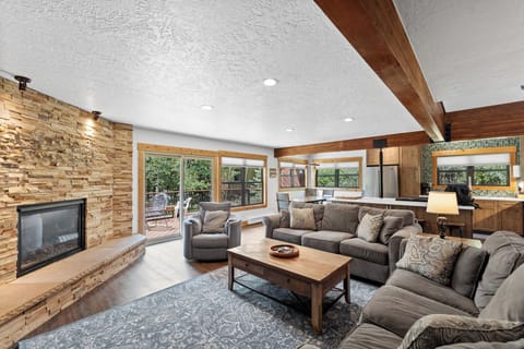 Cozy living area with large mounted flat screen TV, gas fireplace with beautiful stone surround, plenty of seating for your whole group and access to the main balcony.