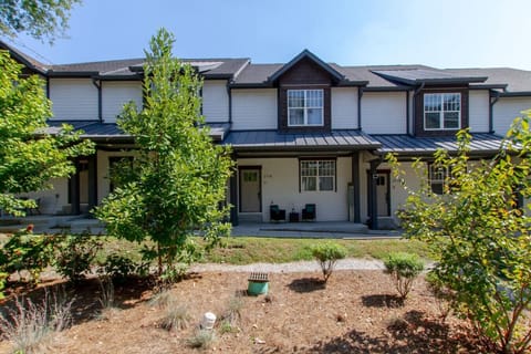 Exterior of two-story craftsman home with dark facade, green trees, and landscaped garden