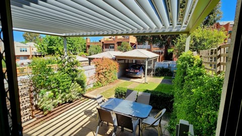Private rear garden with 2 car spaces, shaded motorised Vergola, BBQ & dining