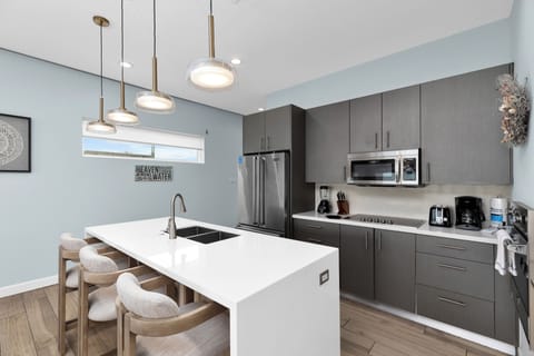 Fully stocked kitchen equipped with stainless steel appliances and a large center island