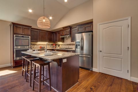 - Modern kitchen island with seating and pendant lights  
- Double ovens and full stainless steel appliances  
- Spacious Airbnb kitchen ideal for family cooking