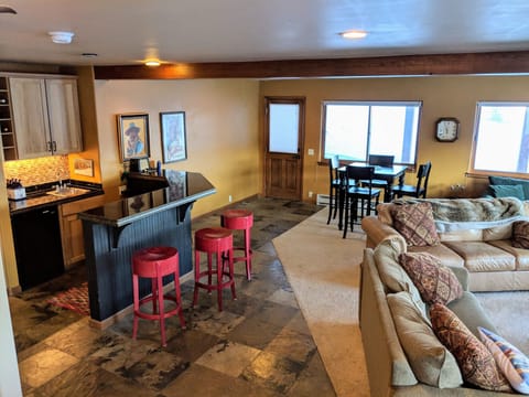 Front door opens to the den with wet bar, mini fridge, TV, and games.