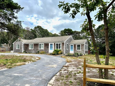Front view of the cape cottage with a circular driveway