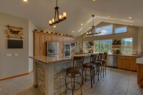 - Modern kitchen with breakfast bar seating  
- Rustic wood cabinetry and elegant lighting fixtures  
- Open layout with scenic mountain views outside