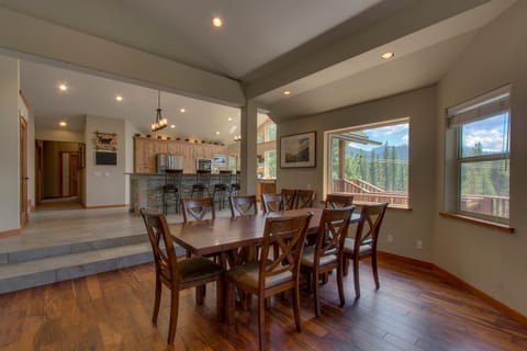 - Large dining table for family gatherings  
- Open-concept design connects kitchen and dining  
- Windows showcase mountain scenery all around