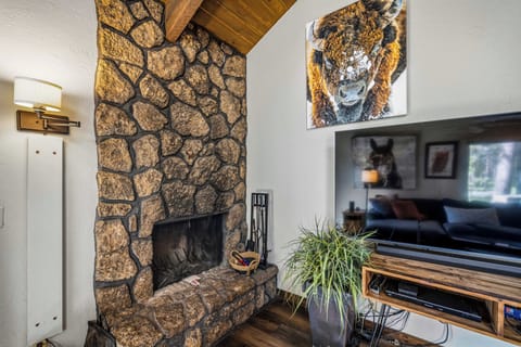 Warm up by your private stone fireplace and unwind with your favorite shows on the big screen. Rustic charm meets modern comfort in this cozy living space.