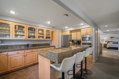 Your spacious kitchen features granite countertops, stainless steel appliances, and a breakfast bar perfect for morning coffee or casual meals.