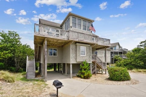This coastal beach house stands ready to welcome you with its natural shingle siding, spacious decks, and prime location steps from the sand. Multiple levels offer flexible space for your group to gather or unwind.