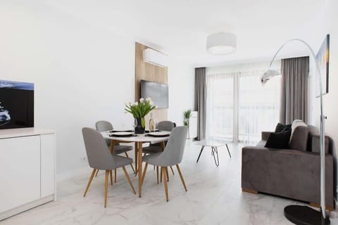 A modern living room with a gray sofa, a small round table, and decor that creates a comfortable atmosphere.