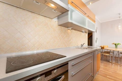 A well-equipped kitchen with wooden cabinets, modern appliances, and a tile backsplash. The layout provides plenty of workspace and storage.