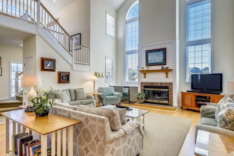 Picture yourself unwinding here, soaking in the natural light that floods this airy living space. Tall ceilings and comfortable seating invite you to relax by the fireplace after your daily adventures.