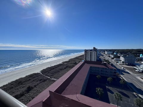 Sun-drenched rooftop view overlooking the sparkling ocean coastline