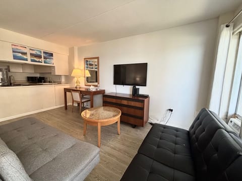 Spacious living area with sofa ,desk and TV