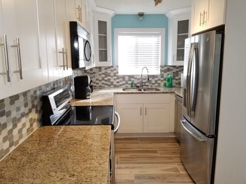 Modern kitchen with stainless steel appliances and granite countertops.
