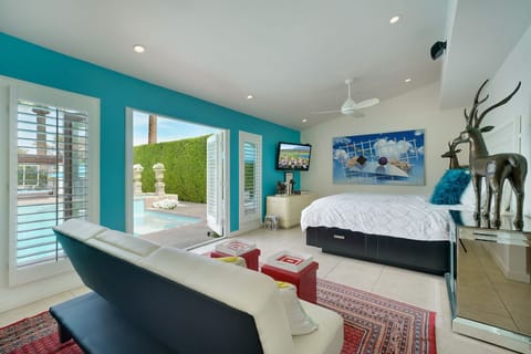 Great room with vaulted ceilng, Cal King bed, large TV and convertible sofa.