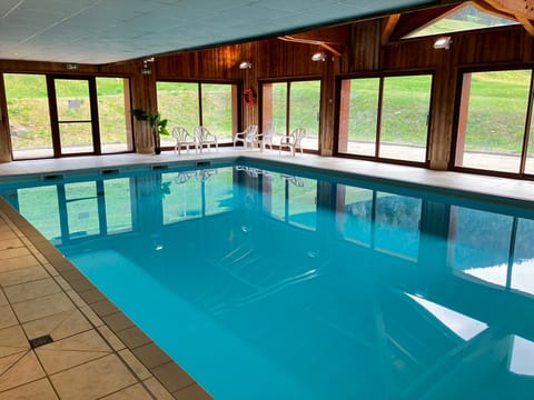 Wind down poolside, with tall windows framing views of the surrounding greenery and mountains