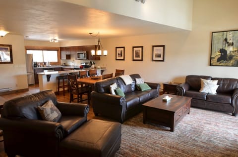 Living Room - The main level of this condo has an open layout with the living room area, dining room, and fully equipped kitchen. The living room area has two, comfortable sofas, one is a sofa sleeper, a TV, and a gorgeous stone fireplace.