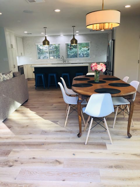 View of the dining area & chefs kitchen. The home has wooden floors throughout.