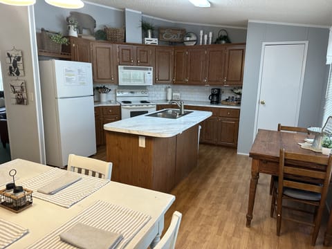 There are two tables in the kitchen so everyone can be seated at the same time.