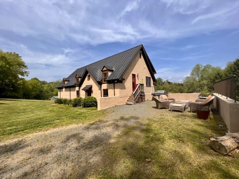 The Cottage showing side entry and seating area. Large BBQ for your convenience