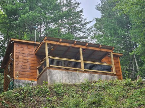 Cabin on the hill in summer, with new covered deck added in 2024.