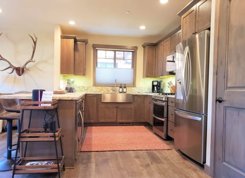 An enormous, antique elk mount casts a dramatic shadow as it peeks through the holiday tree.