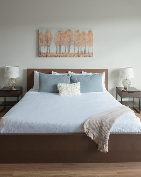 Cozy bedroom retreat with serene coastal artwork and soft linens