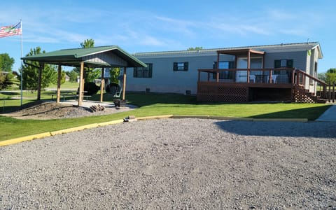 Front of the house. Gazebo has a picnic table, fan and a swing. Firepit also.