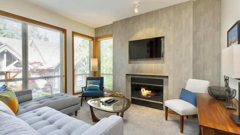 - Modern Whistler living room with fireplace and natural light  
- Cozy lounge area ideal for relaxing after mountain adventures  
- Stylish alpine condo with forest views and warm comfort  
