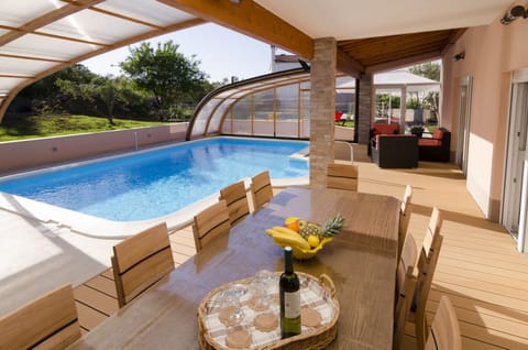 Swimming pool area with an open swimming pool shade and big outside dinning tabl