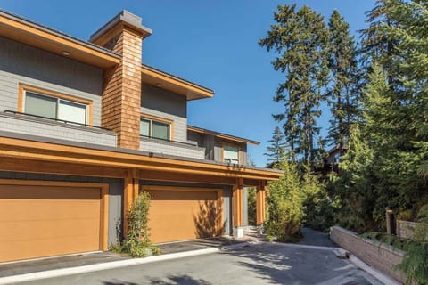 - Modern mountain townhouse with wood accents and scenic forest views  
- Spacious driveway and private garage for convenient parking  
- Peaceful alpine setting surrounded by nature and tall evergreens  