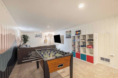 - Fully stocked game room with foosball table, board games, and a mounted TV for entertainment
- Bookshelves and guitars add charm to this cozy space for groups or families
- Relax and play in this fun filled retreat after a day out