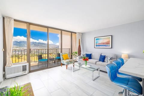 Bright living room with mountain views and a balcony seating area.
