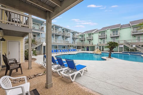 Relax poolside at this charming coastal retreat, where colorful buildings and swaying palms create your perfect vacation backdrop.