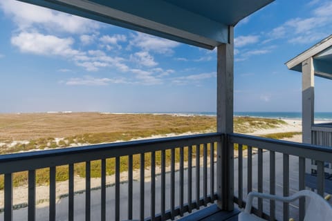 Beachfront balcony offers panoramic ocean views across pristine dunes and coastline.