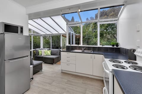 Kitchen and sunroom overlooking stream and bush