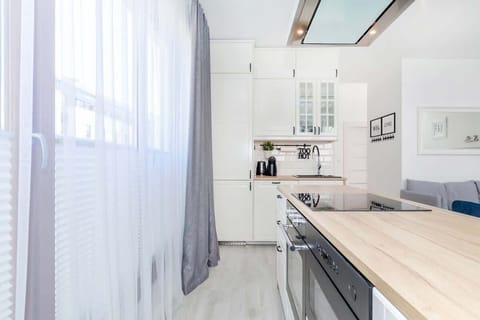 A kitchen corner with a small breakfast bar setup, showing a coffee machine and wooden countertops.