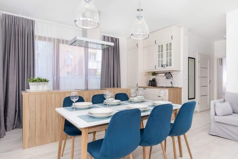 A spacious kitchen area with white cabinets, a countertop, and light coming through a large window.