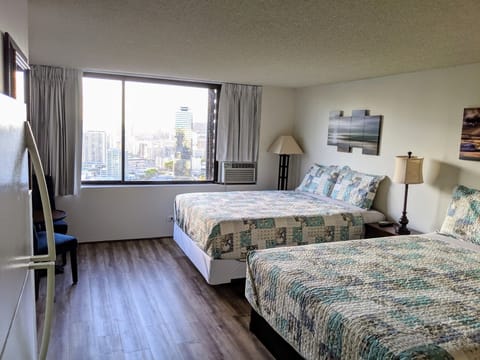 Queen beds, window air conditioner and black out blinds in studio. 