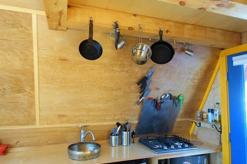 Well appointed kitchen with pots, pans, fridge, stove, kettle, coffee drip cone