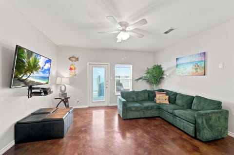 Sink into the plush sectional and let beach breezes drift through the glass door. This bright, airy living room gives you space to stretch out and unwind after a sun-filled day.