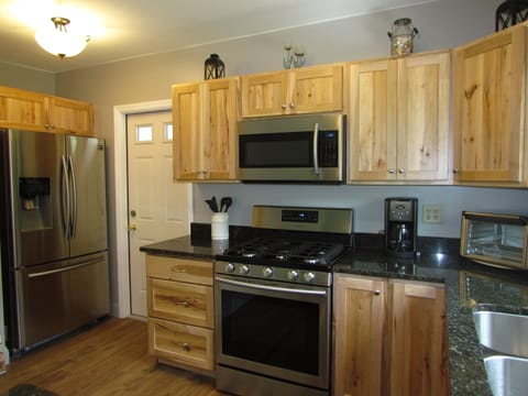 Fully equipped kitchen featuring rustic maple cabinets and granite counter tops.