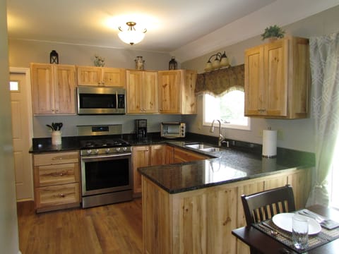 Fully equipped kitchen featuring rustic maple cabinets and granite counter tops.