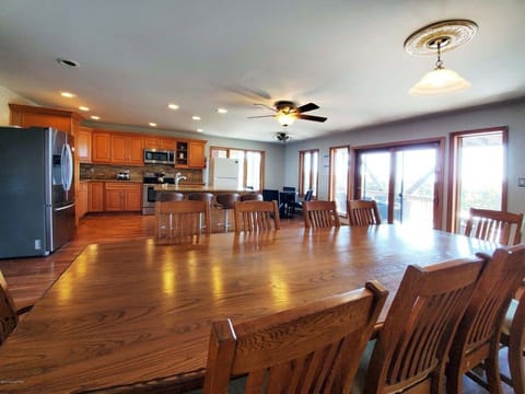 Sliders walks out to BBQ grill, fire pit, dining sets, outdoor sofa, & hot tub.